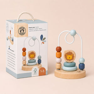 Bead Maze Wooden toy with lion design next to its packaging on a beige background