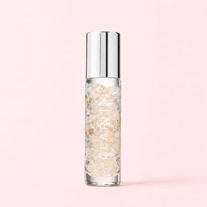 Skincare serum bottle with silver cap on a pink background