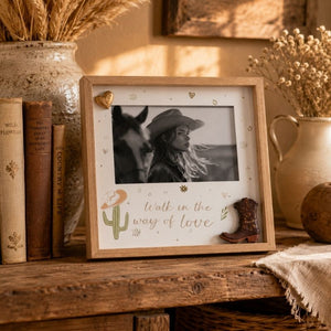 Framed photo of a couple with 'Walk in the Way of Love' text on a rustic shelf with decor items.