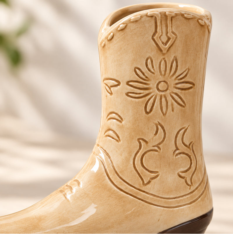 Close-up of embossed detailing on tan cowboy boot ceramic vase