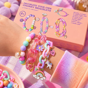 Child wearing handmade chunky bracelets with pastel beads, charms and rainbow details