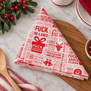 F#ck Christmas paper napkin folded into a triangle on a Christmas table