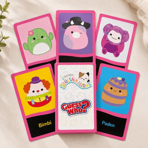 Six colorful Squishmallows character cards arranged in a flat-lay on a soft cream fabric background. The cards feature pink borders and different character illustrations including a green cactus, a pink pig in a black hat, a purple fluffy creature, a clown labeled Bimbi, a dog-and-cat logo card labeled Guess Who?, and a brown cupcake labeled Paden.