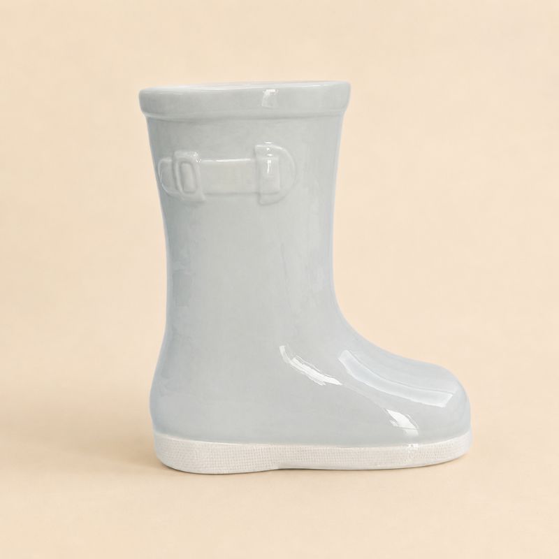 Light blue rain boot on a beige background