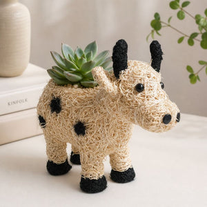 Neutral cow planter styled with books and modern home accents