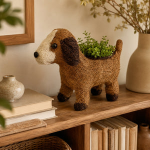 HUSK puppy planter with greenery displayed on a warm wooden shelf