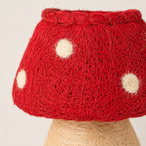 A closeup photography of a A HUSK Toadstool Planter – Red & White 19cm made from red and beige yarn, with a green potted plant inside, photographed on a clean white background.