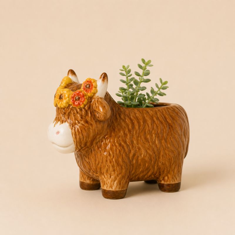 Ceramic cow planter with a plant on a beige background