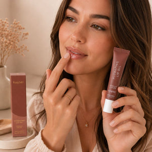 Woman applying Huxter Vanilla Cocoa Hydrating Lip Oil with fingertip in beauty lifestyle scene