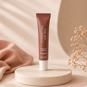 Huxter 15ml Hydrating Lip Oil Vanilla Cocoa displayed on cream pedestal in minimalist studio