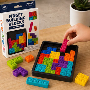 Colorful fidget building blocks set on a table with packaging and a hand interacting with the blocks.
