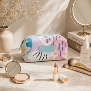 Haven colorful makeup cosmetic bag displayed on a vanity with makeup essentials