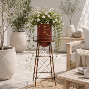 Rustic red metal tower planter displayed in a Scandinavian-inspired patio with white planters and neutral décor.