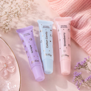 Oh Flossy Grape Natural Lip Gloss with Cotton Candy and Strawberry lip gloss tubes in a pastel pink aesthetic flat lay