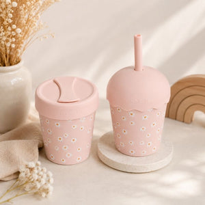 Two Pink Daisy Mini Smoothie Cup & Straw 200ml on a light surface with decorative elements.