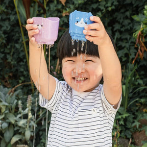 Child playing with Tiger Tribe animal cups bath toy outdoors