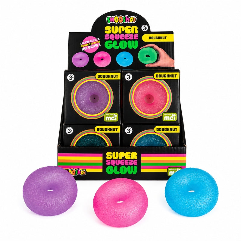 A retail display box of Squisho Super Squeeze Glow Doughnut toys, with three glowing doughnut-shaped squeeze toys in purple, pink, and blue placed in front on a white background.