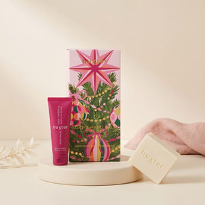 Huxter Soap and Hand Balm Gift Set styled on a soft blush surface with hand balm tube and cream soap