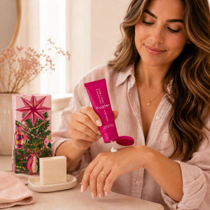 Woman applying Huxter Pink Pepper and Vanilla Bean Hand Balm to her hand in a warm lifestyle setting