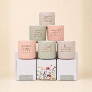 Collection of inspirational ceramic planters in pink, sage, and neutral tones stacked display