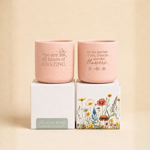 Set of pink ceramic quote planters displayed on gift boxes