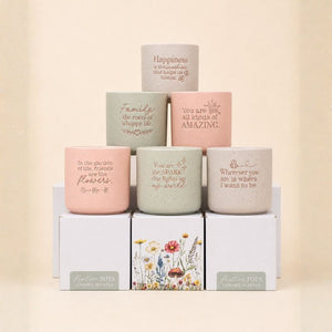 Set of pastel ceramic quote planters arranged in soft neutral background