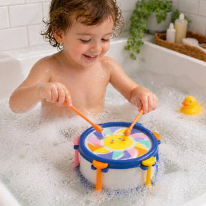 Child playing with Tiger Tribe Sunny Beats bath drum toy during bath time