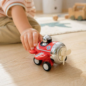 Child playing with Tiger Tribe Presto Plane push toy on wooden surface