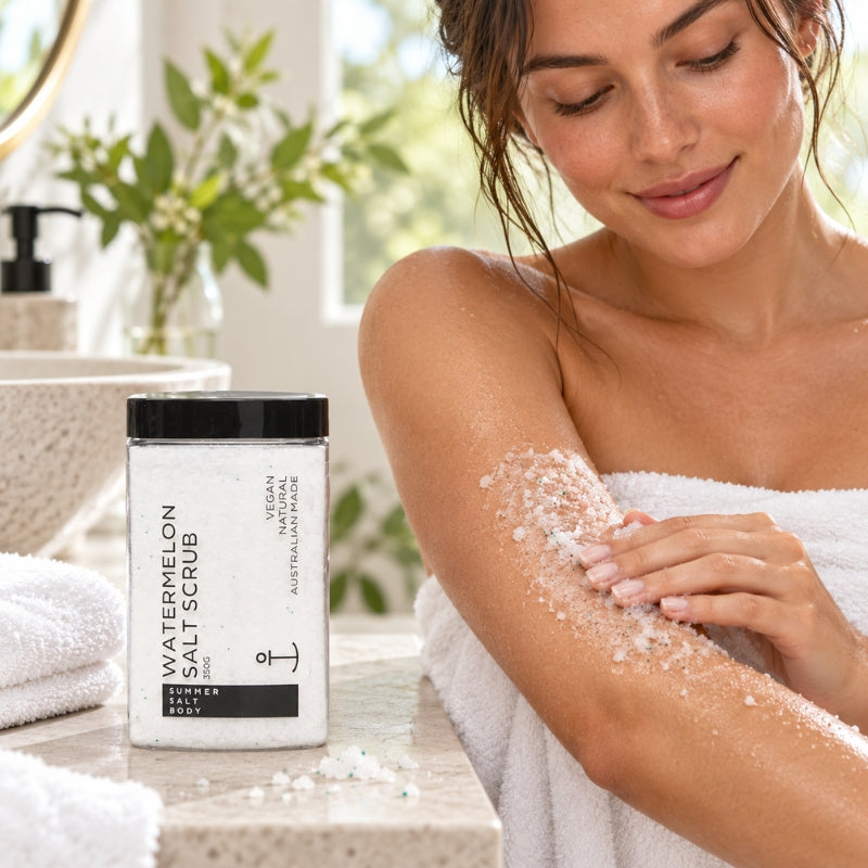 Woman applying Summer Salt Body Watermelon Salt Scrub to her arm in a bright bathroom