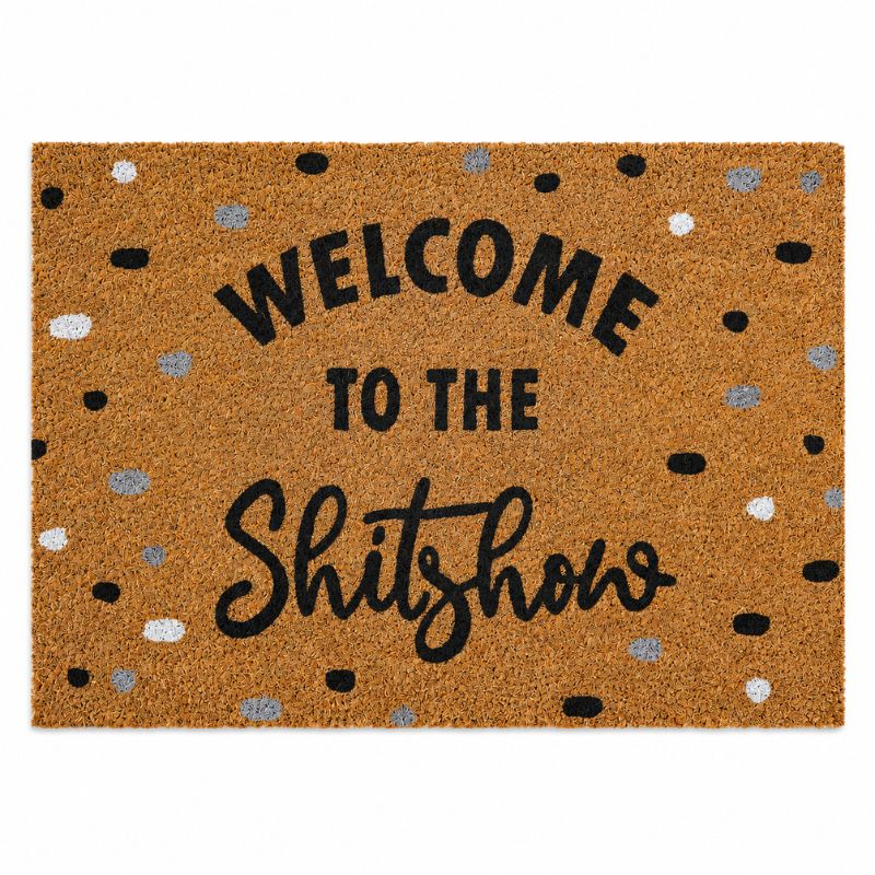 A rectangular coir doormat with the phrase 'WELCOME TO THE Shitshow' in black lettering, surrounded by scattered black, white, and gray polka dots on a natural brown background.-Welcome to the Shitshow Doormat Black