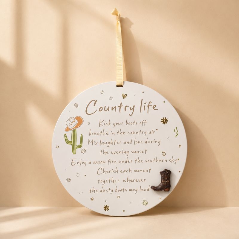 Country Life round hanging plaque with cowboy boot accent and cactus illustration on a warm beige background.