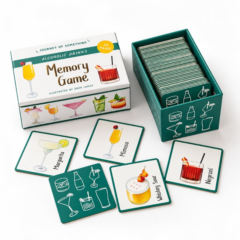 Memory Game for alcoholic drinks, showing the illustrated storage box, an open teal card deck box filled with cards, and several square drink-themed cards laid out on a white background.