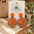 Autumn Bloom Flower Dangle Earrings on a 'Love Shack Giftware' card with plants in the background