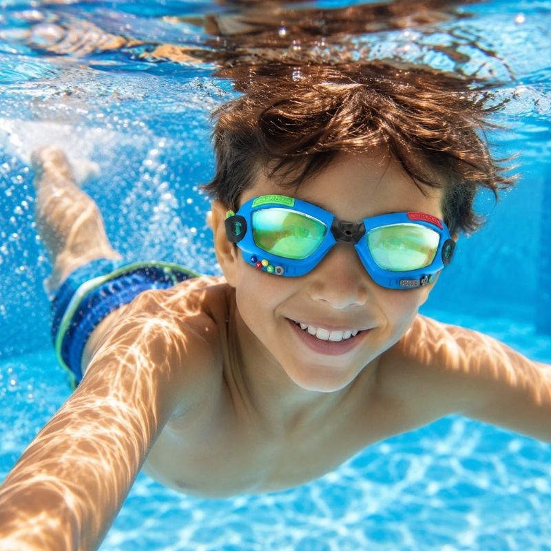 Child swimming underwater wearing Bling2o Gamer Console Cobalt swim goggles in a clear blue pool