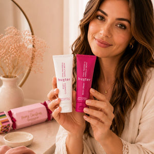 Woman holding Huxter Pink Pepper & Vanilla Bean Body Cleanser and Body Cream duo