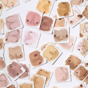 Close-up flat lay of Boobs Memory illustrated matching cards in varied skin tones