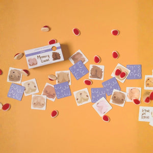 Boobs Memory cards styled on a bright orange background with playful accessories