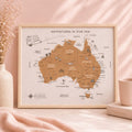 Framed map of Australia with 'Adventures in Our Van' text on a pink surface.