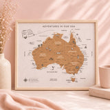 Framed map of Australia with 'Adventures in Our Van' text on a pink surface.