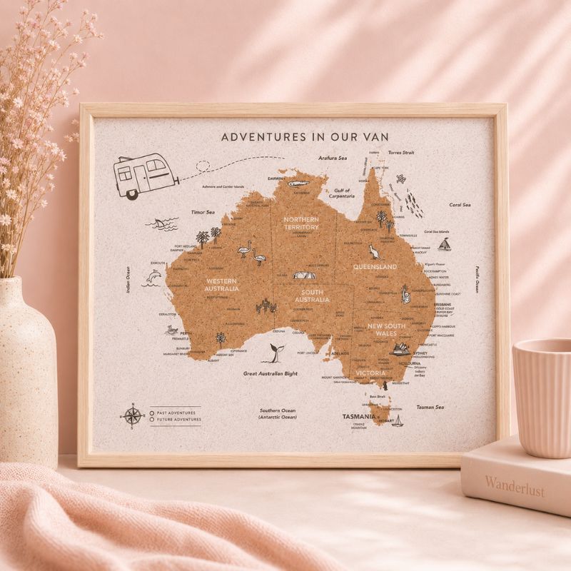 Framed map of Australia with 'Adventures in Our Van' text on a pink surface.