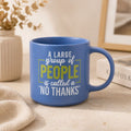 A blue Cheeky No Thanks Mug with a humorous quote printed on it, styled on a light beige tabletop with a neutral background.