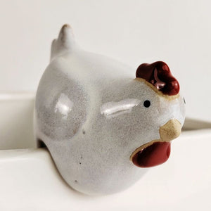 A small ceramic chicken figurine with a speckled light gray body, dark red comb and wattle, and a beige beak, shown close up against a white background.-Chicken Pot Hanger White 6cm
