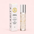 Clarity Essential oil roller with packaging on a pink background