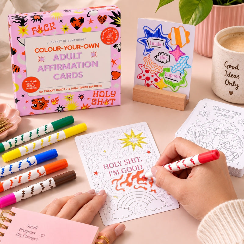 Adult affirmation colouring kit with wooden stand, markers and uncoloured cards on a pink background