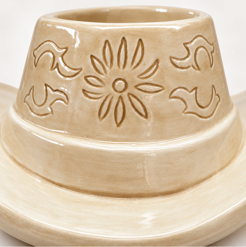 Close-up of embossed floral detailing on tan cowboy hat ceramic planter