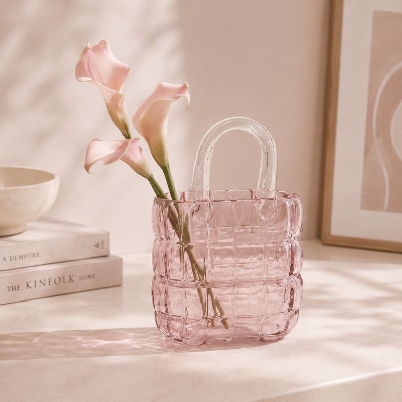 Pink woven vase with flowers on a light surface