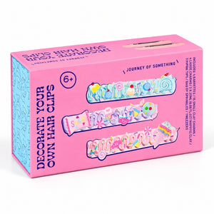 Decorate Your Own Hair Clips - DIY Hair Clip Kit showing illustrated pastel clips and text including 'Decorate Your Own Hair Clips' and 'Journey of Something'.