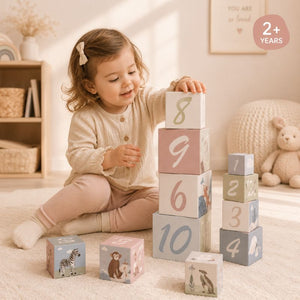 Child playing with a deer stacking cubes number blocks in a cozy room