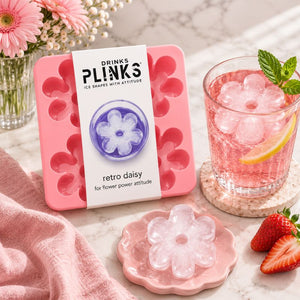 Drinks Plinks - Retro Daisy Pink Ice Cube Tray, styled on a marble surface with a pink drink, strawberries, and flowers.
