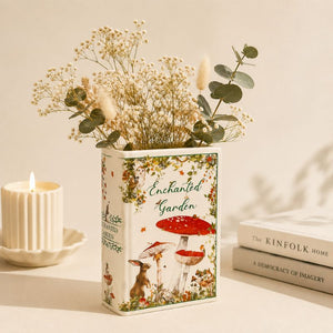 Decorative vase with floral arrangement on a surface with books and a candle.-Loveshack Giftware